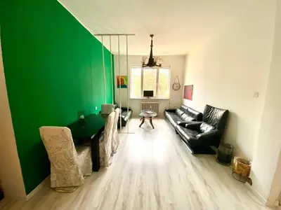 a living room with a couch and a green wall at Happy Appointment in Sofia