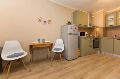 a kitchen with a refrigerator and a table and chairs at Lovely Central 1 Bedroom Condo in Sofia in Sofia