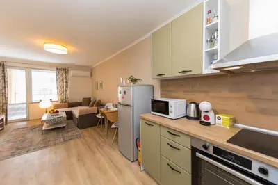 a kitchen with a refrigerator and a living room at Lovely Central 1 Bedroom Condo in Sofia in Sofia