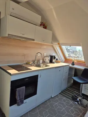 a kitchen with white cabinets and a sink and a window at Cozy Studios Plovdiv in Plovdiv