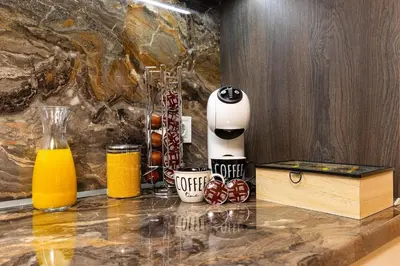 a juicer sitting on top of a counter with orange juice at Warm and Spacious 1BR Apt - Brownie in Plovdiv