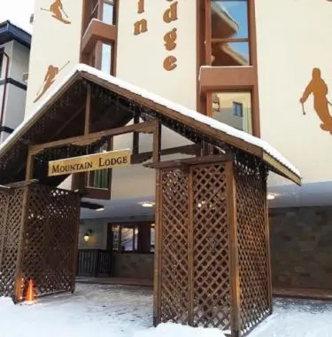 a building with a sign on it in the snow at Апартамент почивка в планината in Pamporovo