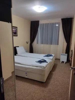 a hotel room with two beds and a window at Апартамент почивка в планината in Pamporovo