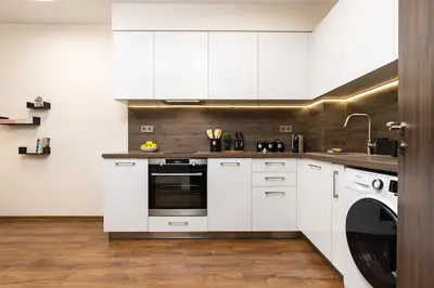 a kitchen with white cabinets and a washing machine at Downtown apt Atelier 53 - Free Parking in Plovdiv