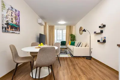 a living room with a table and chairs and a couch at Downtown apt Atelier 53 - Free Parking in Plovdiv