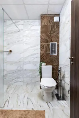 a bathroom with a toilet and a glass shower at Downtown apt Atelier 53 - Free Parking in Plovdiv