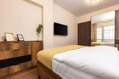 a bedroom with a large bed and a television at Downtown apt Atelier 53 - Free Parking in Plovdiv
