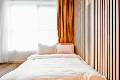 a bed with two pillows in a room with a window at Little Sugar Home in Sofia