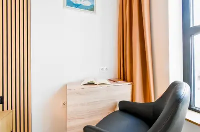 a black chair sitting in front of a window at Little Sugar Home in Sofia