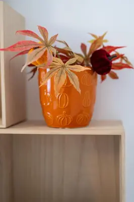 an orange vase with flowers on a shelf at Old Town Bijou in Sofia