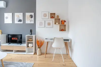 a white living room with a desk and a chair at Old Town Bijou in Sofia