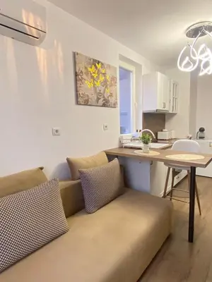 a living room with a couch and a table in a kitchen at Beautiful 2BD Apartment with Large Terrace and Free Parking in Plovdiv