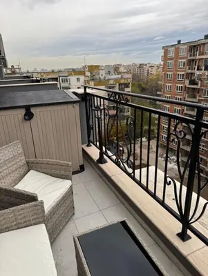 a balcony with a couch and a chair on a balcony at Beautiful 2BD Apartment with Large Terrace and Free Parking in Plovdiv