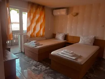 two beds in a room with a window at Къща за гости Орешака in Oreshak