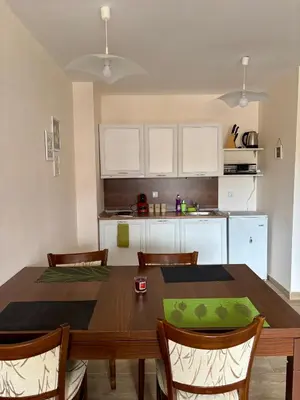 a kitchen with a table and chairs and a kitchen with white cabinets at Snow Apartment Bansko Home2Host in Bansko