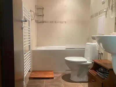 a bathroom with a toilet and a sink and a tub at Kandahar Apartment - top location in Bansko