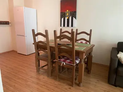 a dining room table with four chairs and a refrigerator at Kandahar Apartment - top location in Bansko