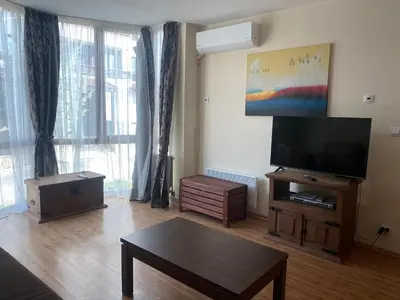 a living room with a flat screen tv and a table at Kandahar Apartment - top location in Bansko