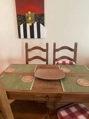 a wooden table with two chairs and a painting on the wall at Kandahar Apartment - top location in Bansko