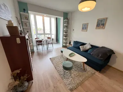 a living room with a blue couch and a table at Bogota Central Apt w Office Space and Wifi near Metro in Sofia