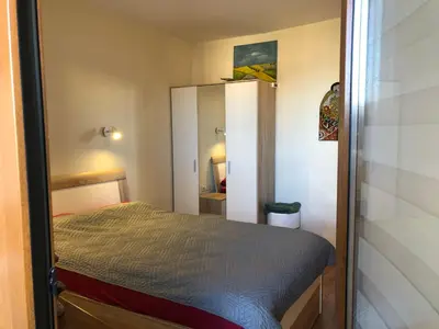 a small bedroom with a bed and a mirror at Artistic Neon Apartment in Bansko