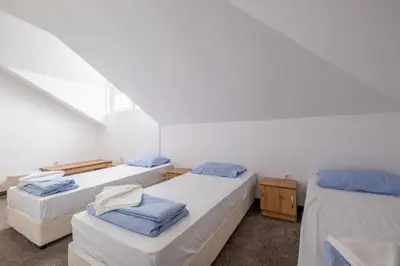 two beds in a room with white walls at Julia rooms in Sofia