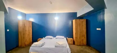 a bedroom with blue walls and a bed with white sheets at Julia rooms in Sofia