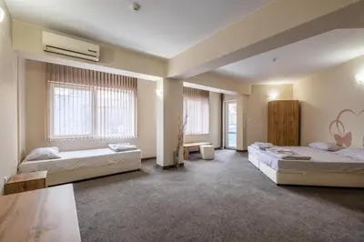 two beds in a room with two windows at Julia rooms in Sofia
