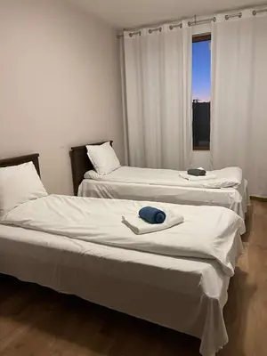 two beds in a hotel room with towels on them at Heart of Plovdiv - 2 bedrooms, Private garage in Plovdiv