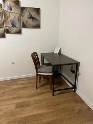 a desk with a chair in a room with paintings at Heart of Plovdiv - 2 bedrooms, Private garage in Plovdiv