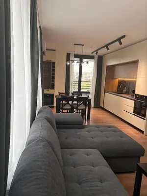 a living room with a couch and a kitchen at New Urban Stay Airport city center metro access in Sofia