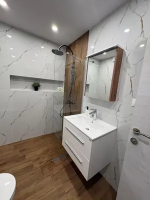 a white bathroom with a sink and a shower at New Urban Stay Airport city center metro access in Sofia