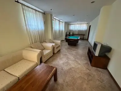 a living room with couches and a tv and a table at St Ivan Rilski Spa & Pool Getaway in Bansko