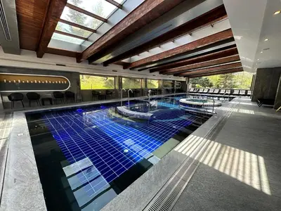 a large swimming pool with blue tiles in a building at St Ivan Rilski Spa & Pool Getaway in Bansko