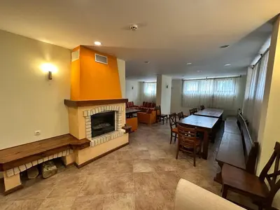 a living room with a fireplace and a dining room at St Ivan Rilski Spa & Pool Getaway in Bansko