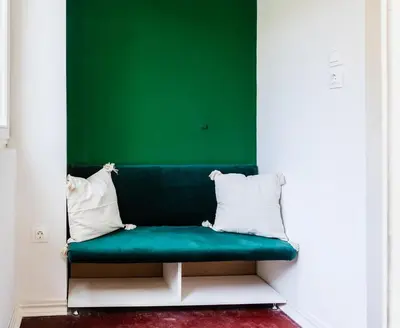 a green couch in a room with a green wall at Paganini House close to Center and Rowing Canal in Plovdiv