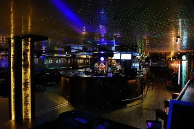 a bar in a nightclub at night with lights at Captain's Apartment in Pamporovo