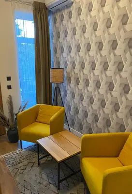 a living room with two yellow chairs and a table at Apartment City by Wohnsol-mit Terrasse im Centrum in Sofia