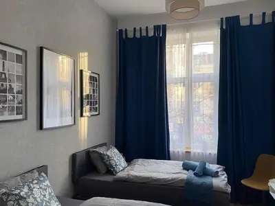 a bedroom with a bed and a window with blue curtains at Apartment City by Wohnsol-mit Terrasse im Centrum in Sofia