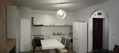 a white kitchen with a table and a refrigerator at Two-Bedroom Apartment Lauta Park 6 Plovdiv in Plovdiv
