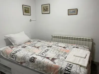 a bed with a comforter on it in a bedroom at Райска тишина in Zlatitsa