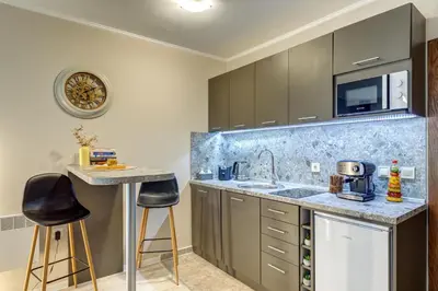 a kitchen with a sink and a counter with stools at Studio in Dream View Resort in Pamporovo
