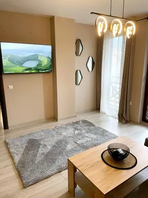 a living room with a table and a tv at Two Modern Apartments in One Building by SI Stay in Bansko