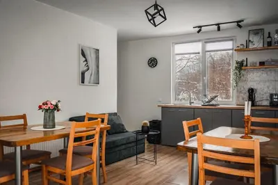 a kitchen and living room with a table and a couch at Guest house by the river in Simitli
