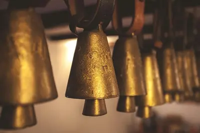 a group of copper bells hanging on a wall at Chalet Jora - Total Chalets in Bansko