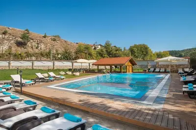 a swimming pool with chairs and a gazebo at Apartment VIP in Hotel Sveti Spas in Velingrad