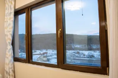 a window with a view of a snow covered field at Apartment Bee Happy, Pchelinski Bani,Hot mineral water in Pchelin