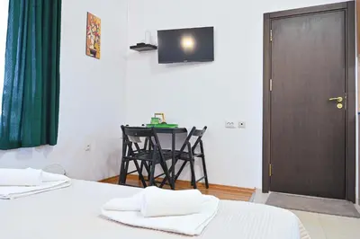 a room with two beds and a table with a television at Apartment Breath - Peaceful Stay Near Gondola Lift by Flat Mаnаger in Bansko