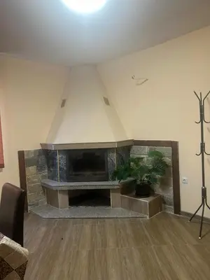a living room with a fireplace in a room at Семеен хотел Струма in Boboshevo
