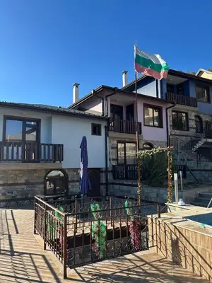 a building with a flag in front of it at Семеен хотел Струма in Boboshevo
